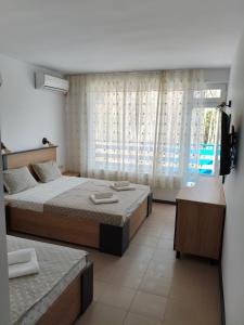 a bedroom with two beds and a large window at Forest Park Kiten in Kiten