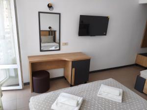 a bedroom with a bed and a desk and a mirror at Forest Park Kiten in Kiten