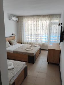a bedroom with two beds and a window at Forest Park Kiten in Kiten