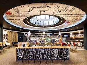 a bar in a restaurant with a large ceiling at ibis Birmingham Centre New Street Station Hotel in Birmingham