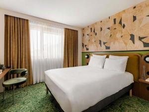 a hotel room with a large bed and a desk at Hôtel Mercure Lyon Centre Lumière in Lyon