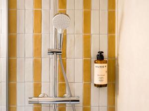 a bathroom with a shower head on a tiled wall at Hôtel Mercure Lyon Centre Lumière in Lyon