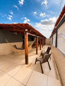 a patio with a chair and a hammock on a house at Casa Chapadeira in Colinas Do Sul