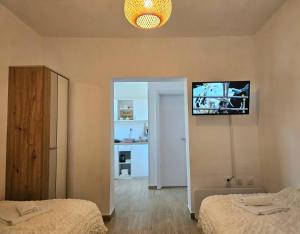 a bedroom with two beds and a television on the wall at Vila Dragica in Bogutovac