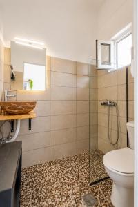 a bathroom with a toilet and a glass shower at Karavaki apartments in Keri +19 photos