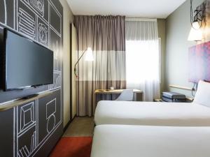 a hotel room with a bed and a flat screen tv at ibis Bordeaux Centre - Gare Saint-Jean in Bordeaux +106 photos