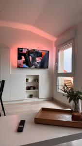 a living room with a tv on the wall at AuraGalega Vionta in Ribeira