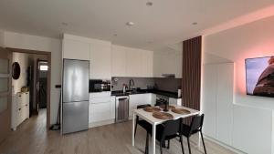 a kitchen with a table with chairs and a refrigerator at AuraGalega Vionta in Ribeira
