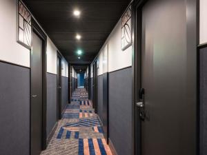 a corridor of stalls with blue and gray walls at Hotel Mercure Wien City in Vienna