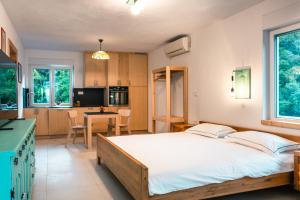 a bedroom with a large bed and a kitchen at Apartmaji Skalabon - Milena in Kanal