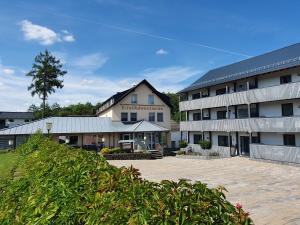 a large building with a courtyard in front of it at Appartementhaus EifelAdventures in Berlingen