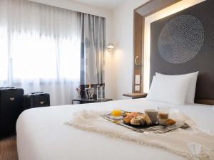 a tray of food on a bed in a hotel room at Novotel Nantes Centre Gare in Nantes