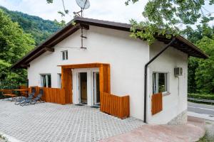 a small white house with a patio at Apartmaji Skalabon - Milena in Kanal
