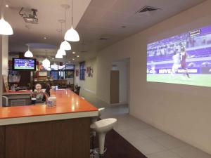 a restaurant with a large screen on the wall at Hotel ibis Faro Algarve in Faro