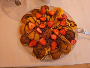 a plate of food with fruit and cookies on a table at Villa Olympia in Durrës +131 photos