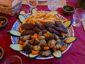 a plate of food with potatoes and vegetables on a table at Oasis Tilogui-Luxury Hotel Restaurant and Desert Excursions In Zagora in Zagora