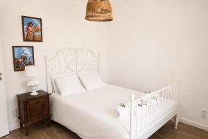 a bedroom with a white bed and a night stand at Chicas Country House in Amieira +17 photos