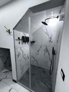 a bathroom with a shower with a glass door at Maréa suite con giardino in Marina di Carrara