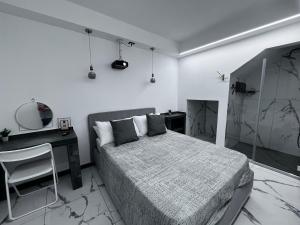a bedroom with a bed and a desk and a mirror at Maréa suite con giardino in Marina di Carrara