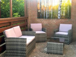 two wicker chairs and a table on a patio at Palm89 in Warmenhuizen +14 photos