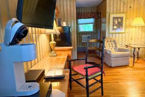 a living room with a tv and a chair at Azalea Garden Inn in Blowing Rock