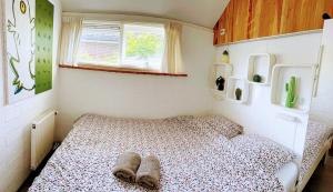 a small bedroom with a bed with slippers on it at Palm89 in Warmenhuizen