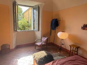 a bedroom with a bed and a window and a chair at Le Guadalupe by Luigi in Volterra +41 photos