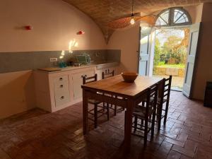 a kitchen with a wooden table and some chairs at Le Guadalupe by Luigi in Volterra