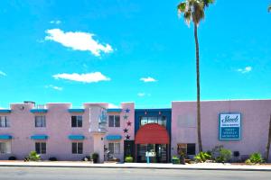 a building with a palm tree in front of it at Sands Inn & Suites Lake Havasu City in Lake Havasu City
