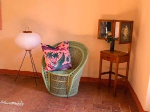 a wicker chair with a pillow and a lamp in a room at Le Guadalupe by Luigi in Volterra
