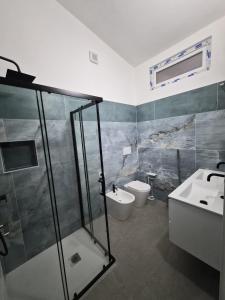 a bathroom with a shower and a sink and a toilet at House Manu in Assemini