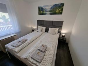 a bedroom with a bed with two towels on it at Kakukkfészek Apartmanok in Kiskunmajsa