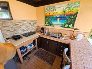 a kitchen with a sink and a painting on the wall at Outback Hermosa in Playa Hermosa
