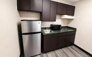 a small kitchen with a refrigerator and a sink at Studio Lodge of Augusta in Augusta