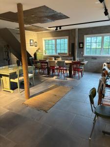 a large room with tables and chairs and windows at Smedjan Bed and Breakfast in Varberg