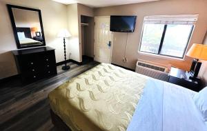 a hotel room with a bed and a television at Studio Lodge of Augusta in Augusta +2 photos