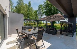 a patio with a table and chairs and an umbrella at Country house Greenfields in Gospić