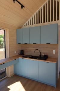 a kitchen with white cabinets and a sink at Domki Paradise Charzykowy in Charzykowy