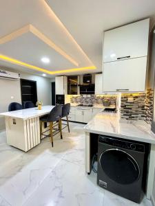 a kitchen with a dishwasher and a table and chairs at Luxurious Altitude in Lekki