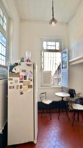 a kitchen with a refrigerator and a table with chairs at Casa Igara Hostel in Belém