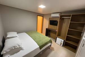 a bedroom with a bed and a desk and a television at Pousada Beach in Capão da Canoa