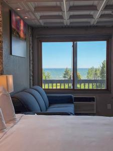 a bedroom with a bed and a large window at Manistique Sands in Manistique