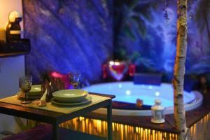 a bathroom with a tub with a table and glasses at Moonlight Jungle Suit Luxury experience in Avola