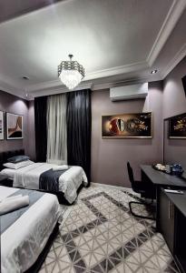 a bedroom with two beds and a desk and a chandelier at Light guest house in Samarkand