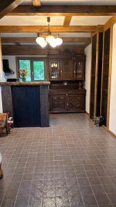 a large kitchen with wooden cabinets and a tile floor at Cabana Pârâul Lupilor in Răchitiş +12 photos
