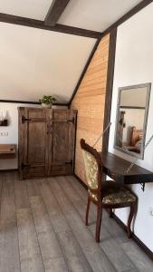 a room with a table and a mirror and a chair at Cabana Pârâul Lupilor in Răchitiş