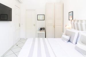 a white bedroom with a bed and a tv at Queen Suite - Luxury Rooms in Forio d'Ischia +83 photos
