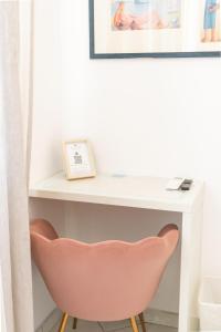 a desk with a pink chair in a room at Queen Suite - Luxury Rooms in Forio d'Ischia