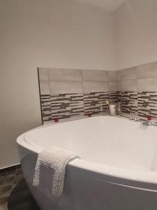 a white bath tub with a towel on it at Arcanum Apartman in Makó