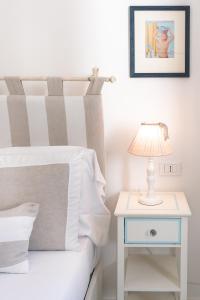 a bed with a nightstand and a lamp on a side table at Queen Suite - Luxury Rooms in Forio d'Ischia